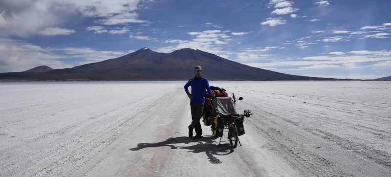 Romain et son vélo chargé de sacoches sur un salar en Amérique du Sud